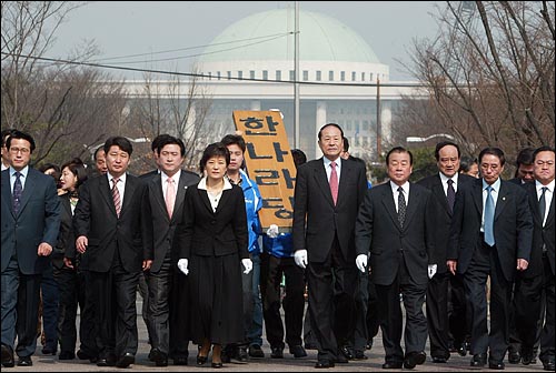 지난 2004년 3월 23일 한나라당 대표에 선출된 박근혜 대표는 바로 이튿날 당사를 천막으로 옮겼다. 박 대표가 당직자들과 당 현판을 들고 천막당사로 걸어가고 있다. 